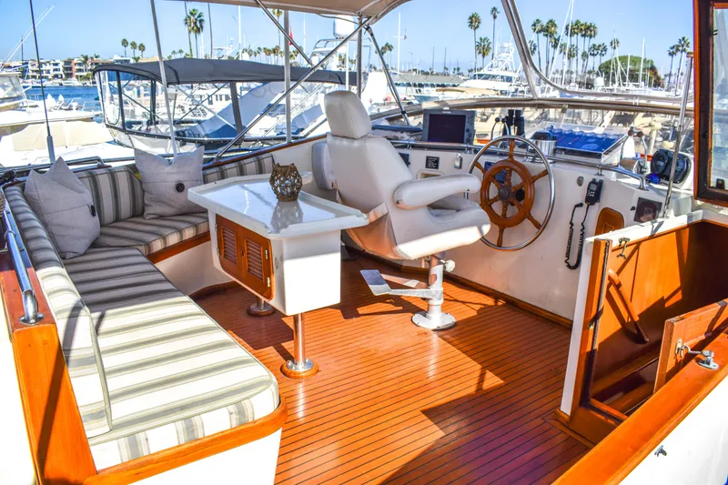 Slide: The Image of 1984 Angel Defever LRC yacht interior with striped seating, wooden flooring, and steering wheel. - 2