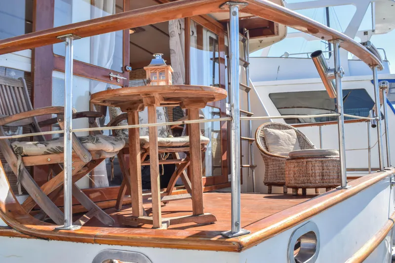 Slide: The Image of 1984 Angel Defever LRC yacht deck with wooden furniture and glass railing. - 21