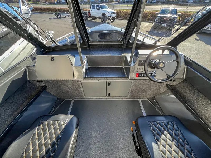 Slide: The Image of Interior view of 2024 North River 25 Seahawk boat cockpit with steering wheel and seats. - 8