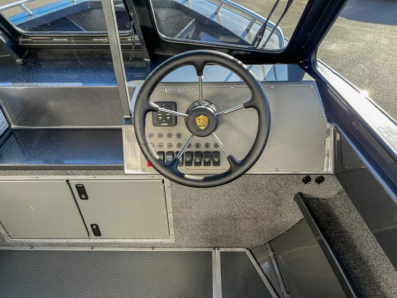 Slide: The Image of 2024 North River 25 Seahawk boat dashboard with steering wheel and control panel. - 9