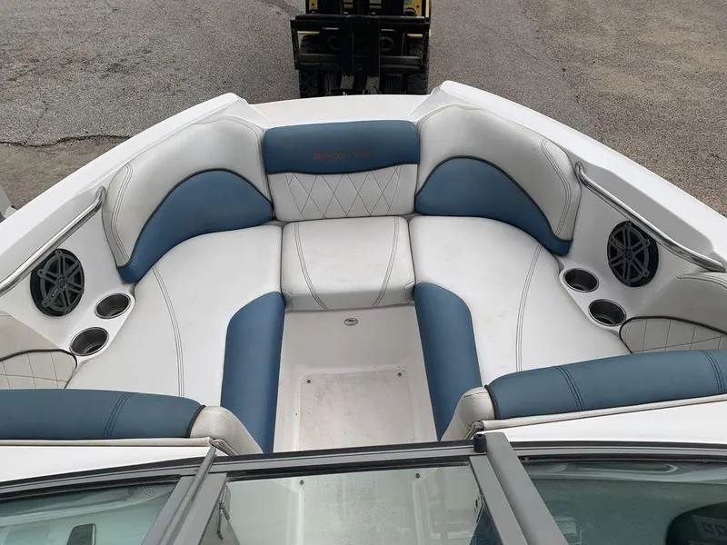 Slide: The Image of 2012 MasterCraft X2 boat interior with blue and white seating, cup holders, and speakers. - 5