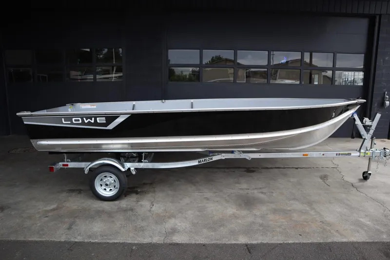 Slide: The Image of 2024 Lowe WV1670 boat on a trailer in front of a garage. - 1