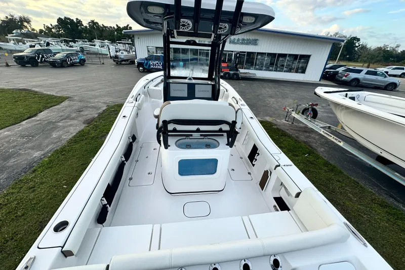 Slide: The Image of 2024 Tidewater 256 LXF boat interior, center console, white seating, and fishing equipment. - 13