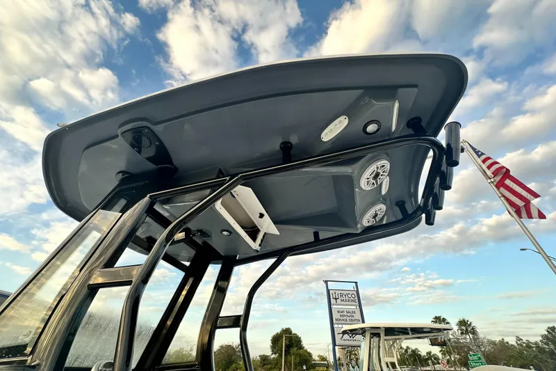 Slide: The Image of 2024 Tidewater 256 LXF boat T-top with speakers and American flag in background. - 16