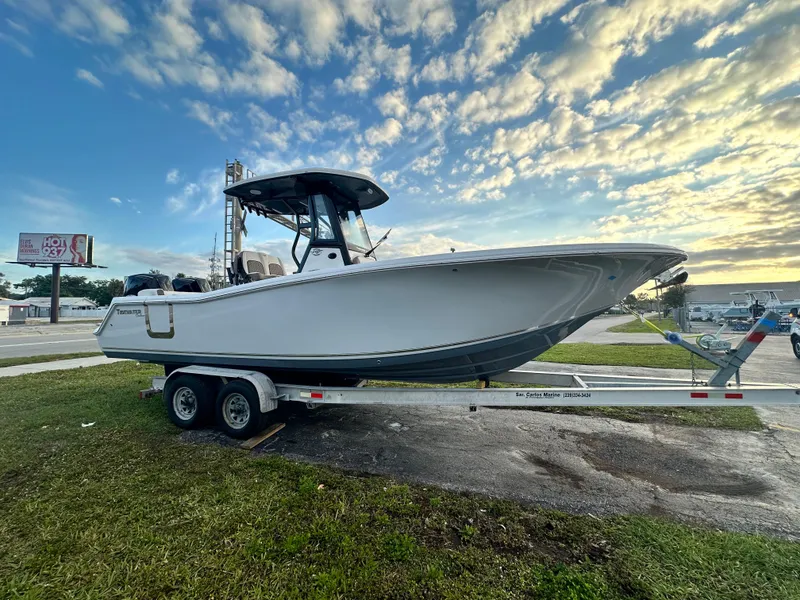 Slide: The Image of 2024 Tidewater 256 LXF boat on a trailer under a partly cloudy sky. - 7