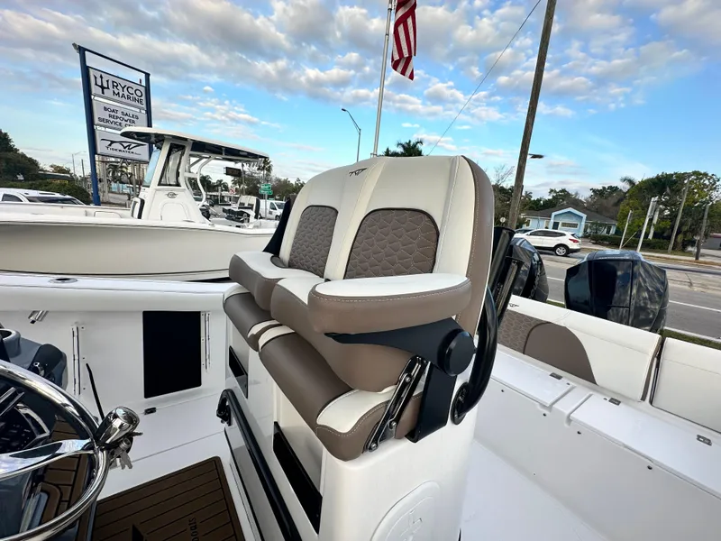 Slide: The Image of 2024 Tidewater 256 LXF boat interior with cushioned seating and steering wheel. - 9