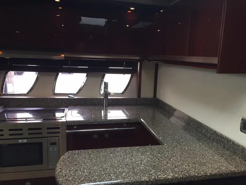 Slide: The Image of 2008 Sea Ray 480 Sundancer helm with dual white leather seats and advanced navigation controls. - 17