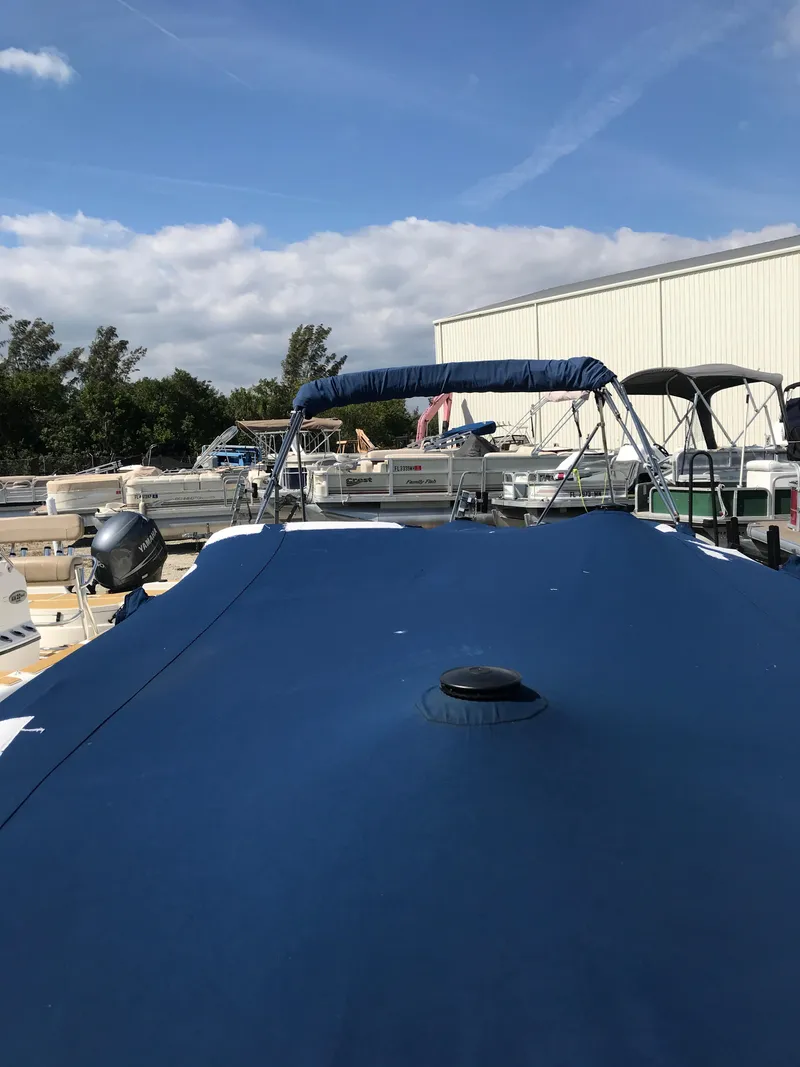 Slide: The Image of 2005 Chaparral Sunesta 252 boat with blue cover, docked outdoors under a clear sky. - 10