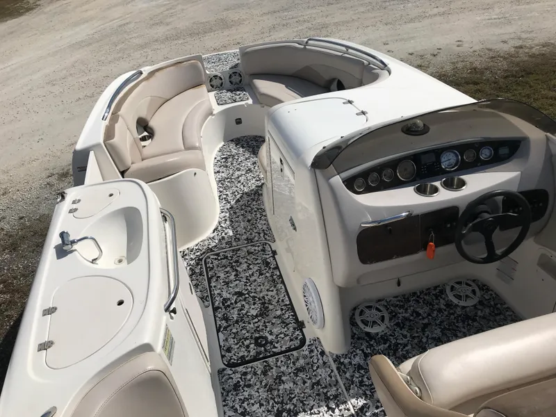 Slide: The Image of 2005 Chaparral Sunesta 252 boat interior with seating, steering wheel, and sink. - 17
