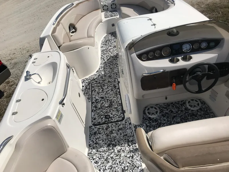 Slide: The Image of 2005 Chaparral Sunesta 252 boat interior with steering wheel, seating, and sink. - 18