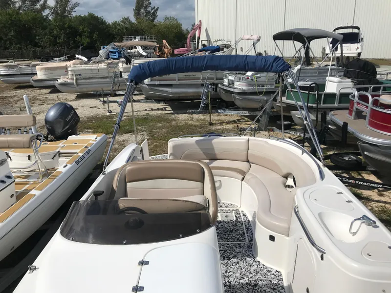Slide: The Image of 2005 Chaparral Sunesta 252 boat with seating, parked among other boats outdoors. - 23
