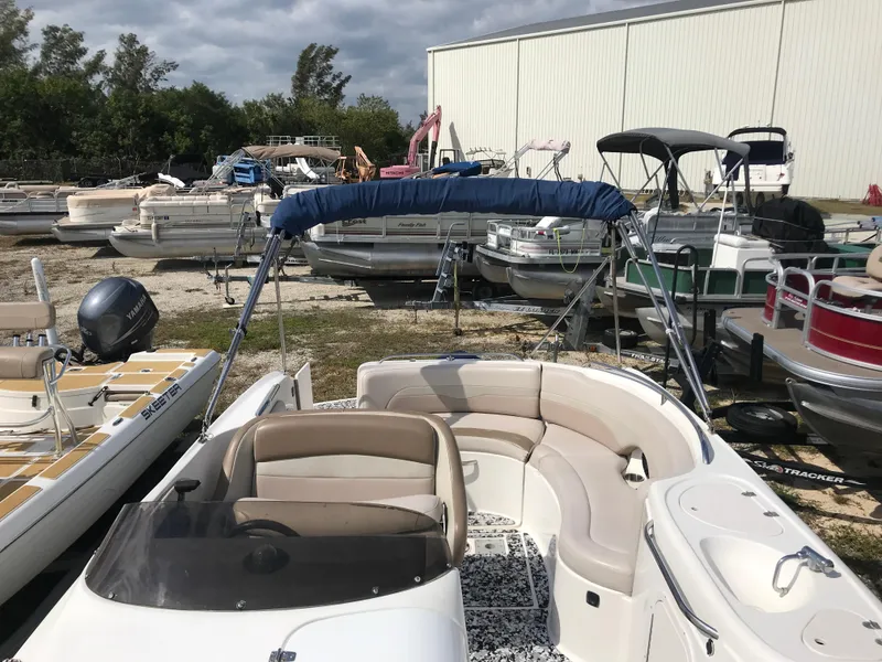 Slide: The Image of 2005 Chaparral Sunesta 252 boat with seating, parked among other boats outdoors. - 24