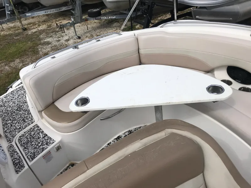 Slide: The Image of 2005 Chaparral Sunesta 252 boat interior with seating and table, featuring cup holders. - 28