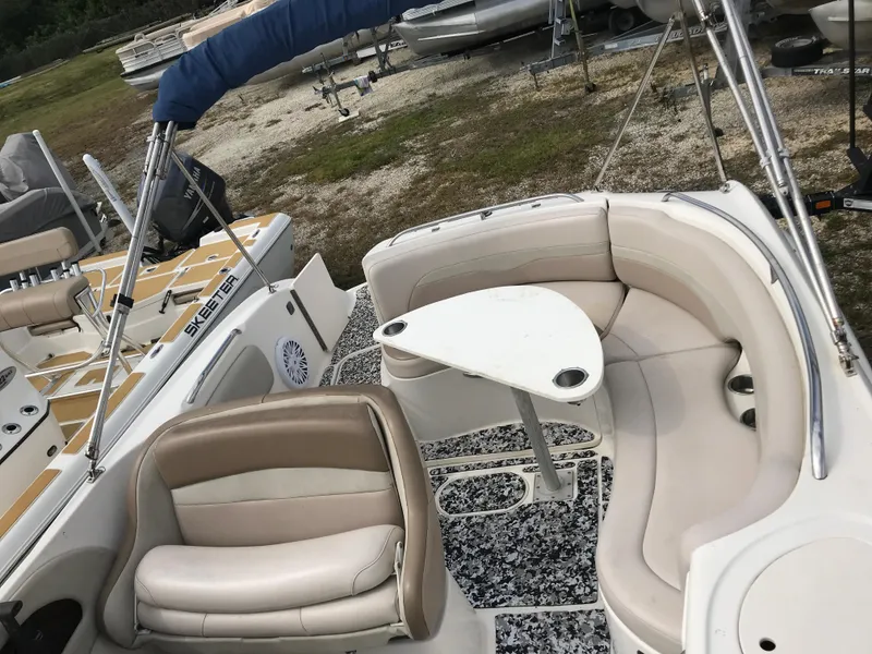 Slide: The Image of 2005 Chaparral Sunesta 252 boat interior with seating and table, parked on gravel. - 31