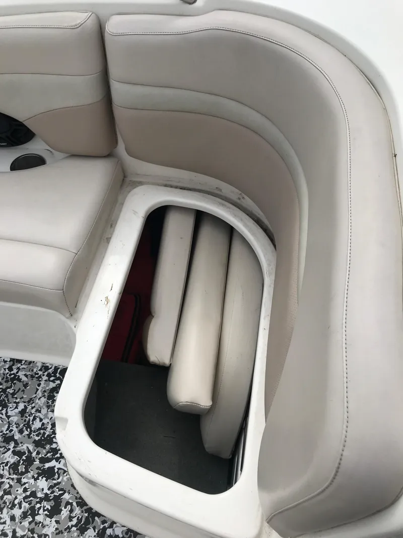 Slide: The Image of 2005 Chaparral Sunesta 252 boat interior with open storage compartment and beige seating. - 34