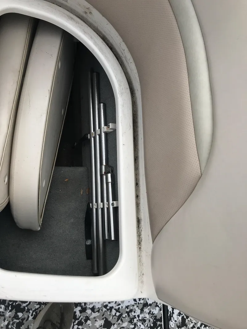 Slide: The Image of Storage compartment in a 2005 Chaparral Sunesta 252 boat with cushions and metal poles. - 35