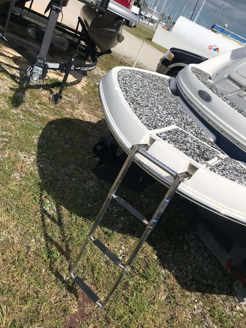 Slide: The Image of 2005 Chaparral Sunesta 252 boat with ladder on grassy area near trailers. - 48