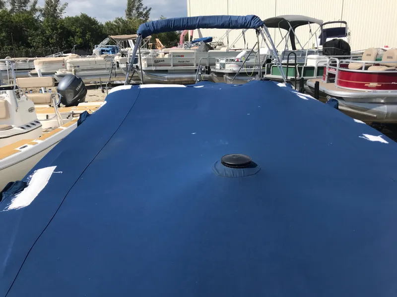Slide: The Image of 2005 Chaparral Sunesta 252 boat with blue cover in marina setting. - 9