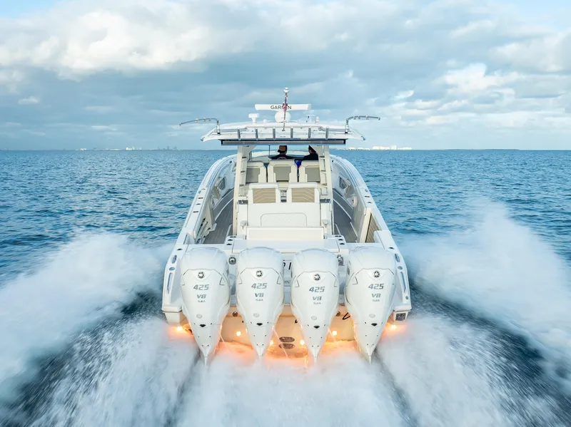 Slide: The Image of 2022 Pursuit 428S boat with four powerful outboard engines cruising on open water. - 1