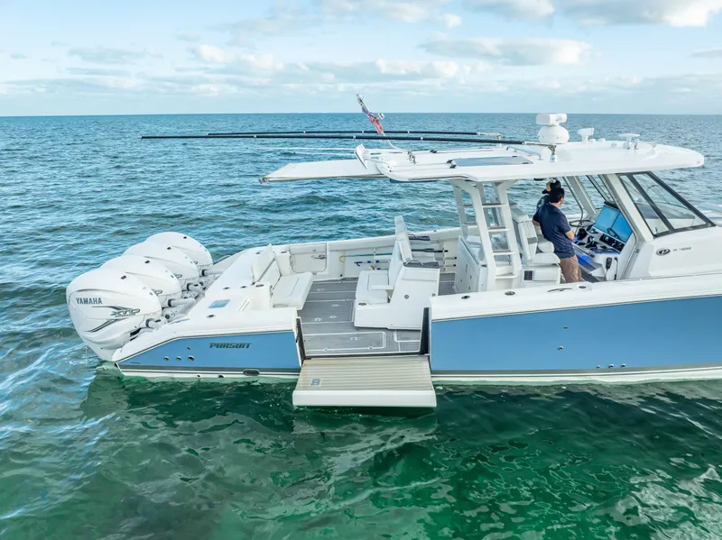 Slide: The Image of 2022 Pursuit 428S boat on open water with triple Yamaha engines. - 12