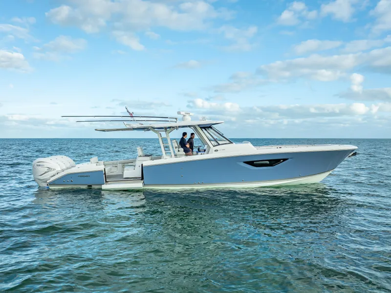 Slide: The Image of 2022 Pursuit 428S boat cruising on open water under a blue sky. - 2