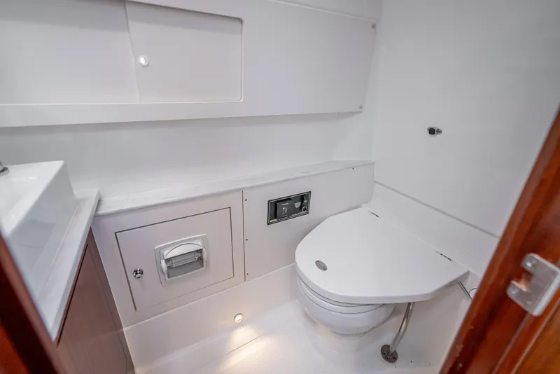Slide: The Image of Modern bathroom in 2022 Pursuit 428S boat with toilet and storage compartments. - 21