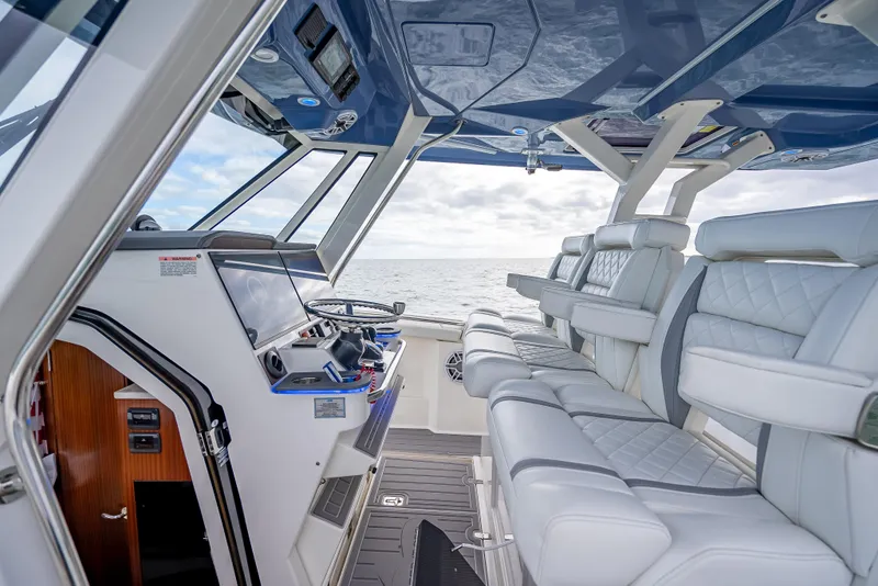 Slide: The Image of Interior of 2022 Pursuit 428S boat with luxurious seating and advanced navigation system. - 36