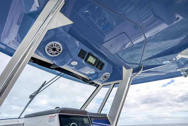 Slide: The Image of 2022 Pursuit 428S boat interior with blue ceiling, speakers, and navigation equipment. - 37