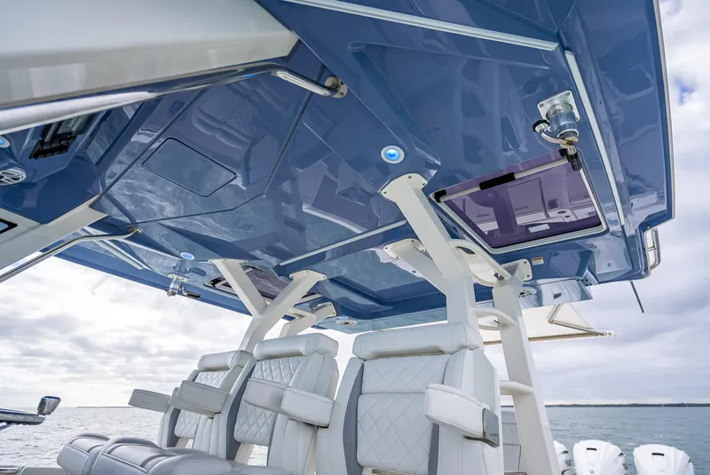 Slide: The Image of 2022 Pursuit 428S boat interior with luxurious seating and blue canopy. - 38