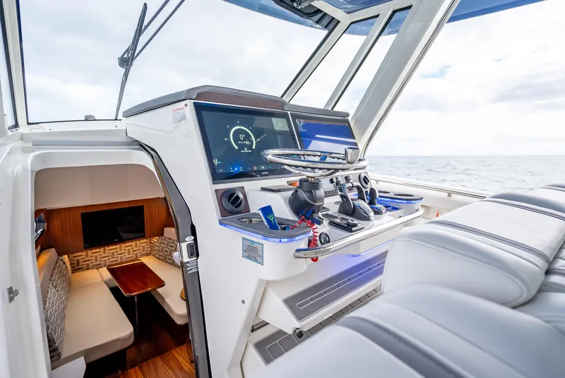 Slide: The Image of 2022 Pursuit 428S boat interior with modern helm and cabin seating. - 39