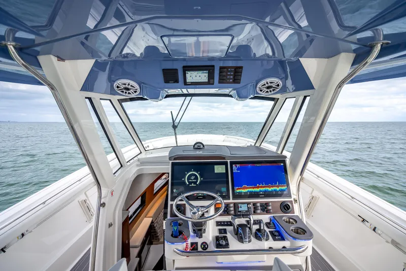 Slide: The Image of 2022 Pursuit 428S boat helm with advanced navigation system and ocean view. - 44