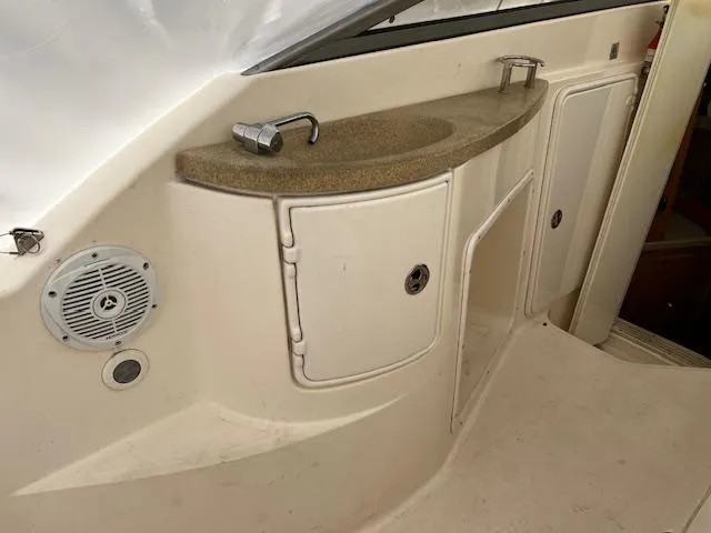 Slide: The Image of 2004 Regal 2665 Commodore Express boat interior with sink and storage compartments. - 10