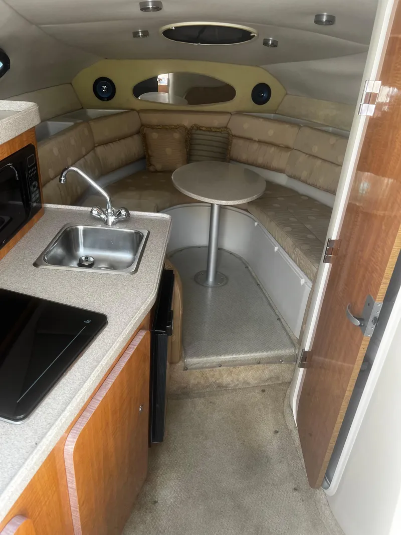 Slide: The Image of 2004 Regal 2665 Commodore Express cabin interior with kitchenette and seating area. - 16