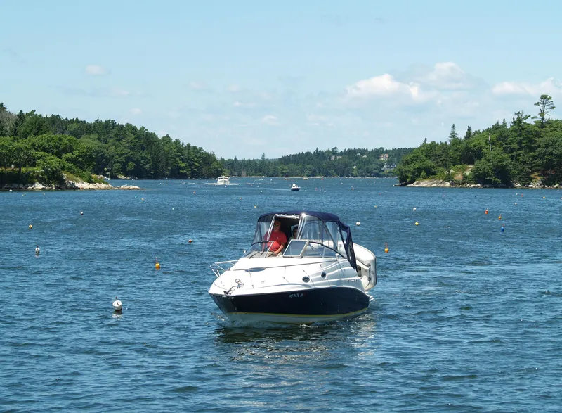 Slide: The Image of 2004 Regal 2665 Commodore Express boat cruising on a scenic lake. - 2