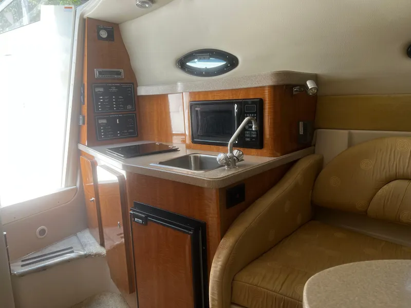 Slide: The Image of 2004 Regal 2665 Commodore Express boat interior with kitchenette and seating area. - 20