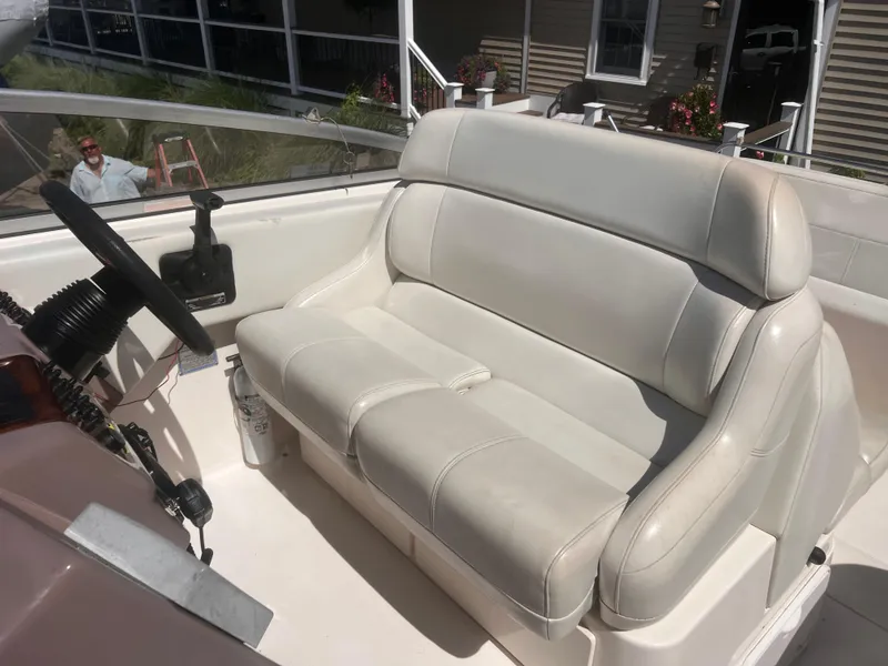 Slide: The Image of 2004 Regal 2665 Commodore Express boat interior with white leather seating and steering wheel. - 5