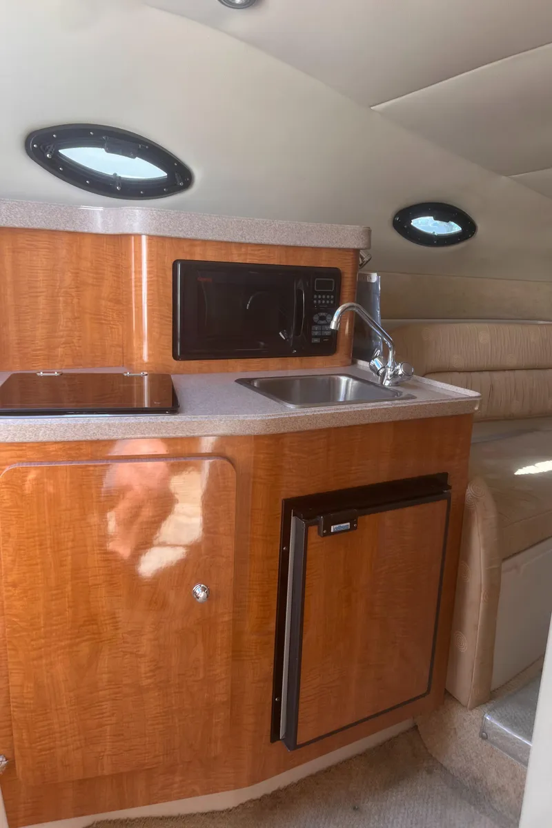 Slide: The Image of 2004 Regal 2665 Commodore Express cabin interior with kitchenette and seating area. - 17
