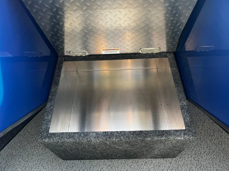 Slide: The Image of 2024 Thunder Jet 185 Luxor storage compartment with diamond plate and carpeted interior. - 14