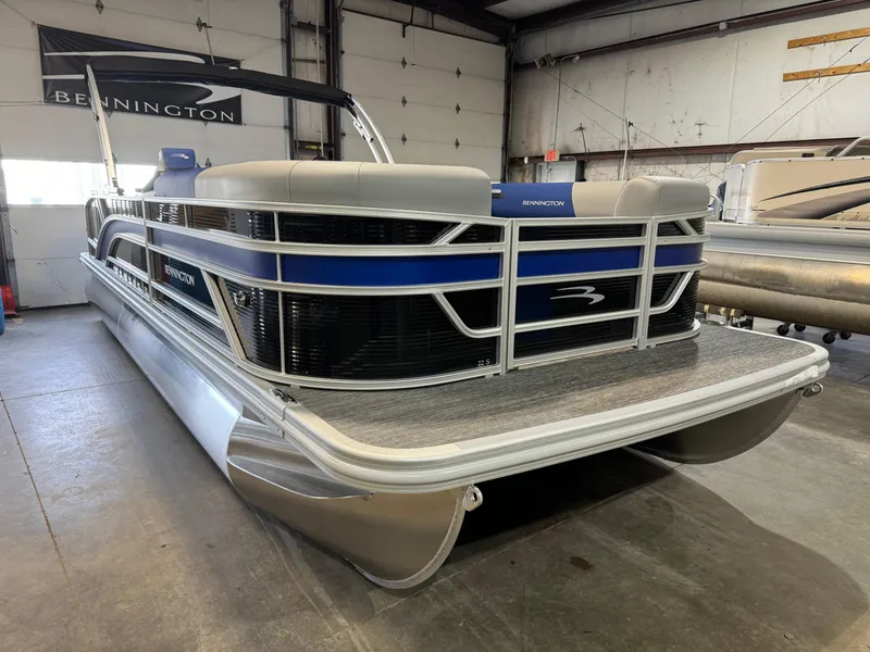 Slide: The Image of 2024 Bennington 22SSB pontoon boat in showroom, featuring sleek design and modern amenities. - 0