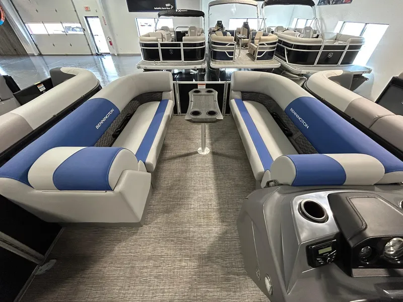Slide: The Image of 2024 Bennington 22SSB pontoon boat interior with blue and gray seating, modern design. - 6