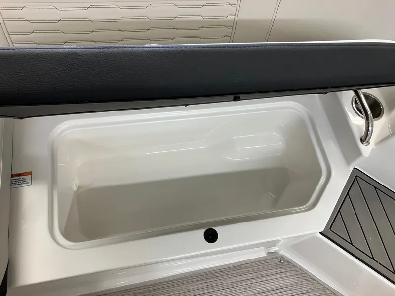 Slide: The Image of 2024 Sea Ray SPX 190 boat storage compartment with cushioned seat. - 11