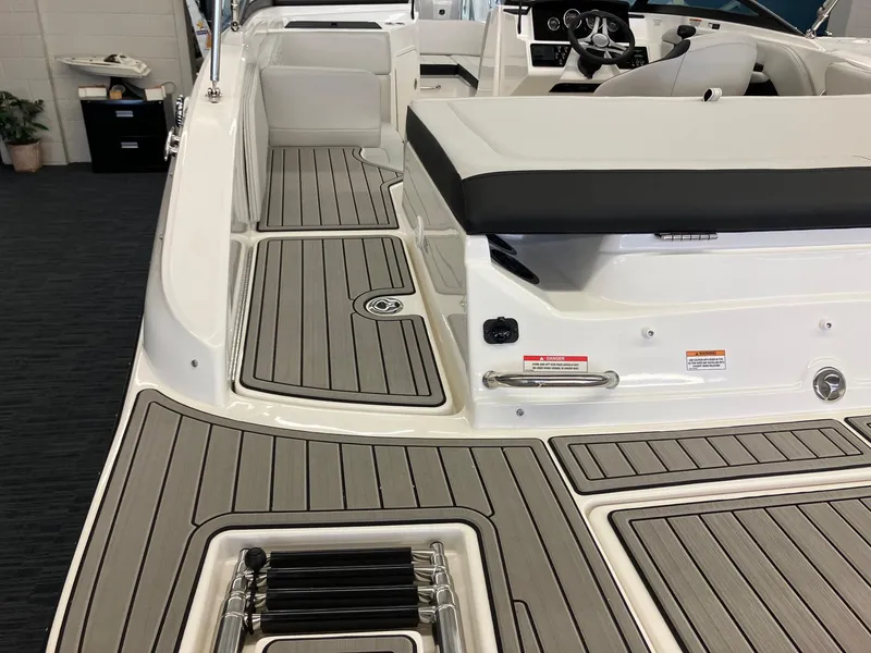 Slide: The Image of 2024 Sea Ray SPX 190 boat interior with teak flooring and white seating. - 3