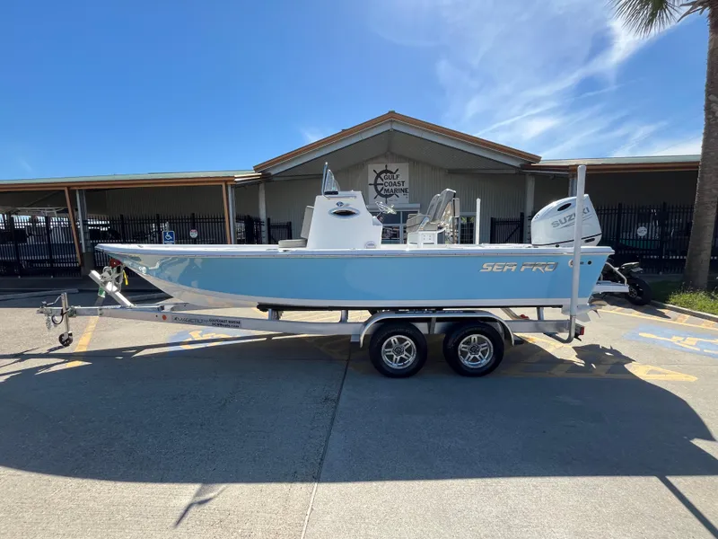 The Image of 2024 Sea Pro 230 Bay boat on a trailer in front of a dealership. - 0