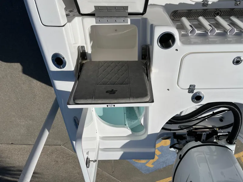 Slide: The Image of 2024 Sea Pro 230 Bay boat with open storage compartment and fishing rod holders. - 21