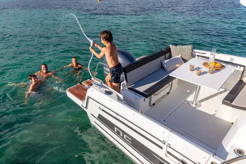 Slide: The Image of 2024 Jeanneau NC 795 Weekender S2 with people swimming and relaxing on the boat. - 21