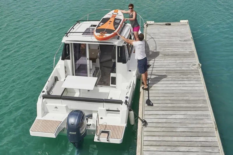 Slide: The Image of 2024 Jeanneau NC 795 Weekender S2 at dock, people loading paddleboard. - 23