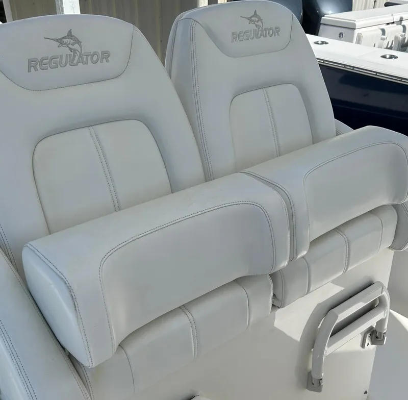 Slide: The Image of 2020 Regulator 26XO boat seats, featuring white cushioned design and Regulator logo. - 24