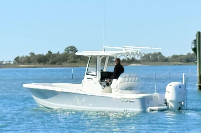 Slide: The Image of 2020 Regulator 26XO boat on calm water, featuring a sleek design and outboard motor. - 4