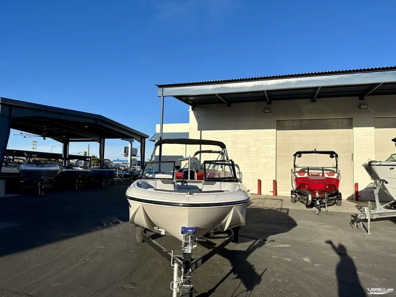 Slide: The Image of 2025 Bayliner M17 boat on trailer at dealership under clear blue sky. - 3