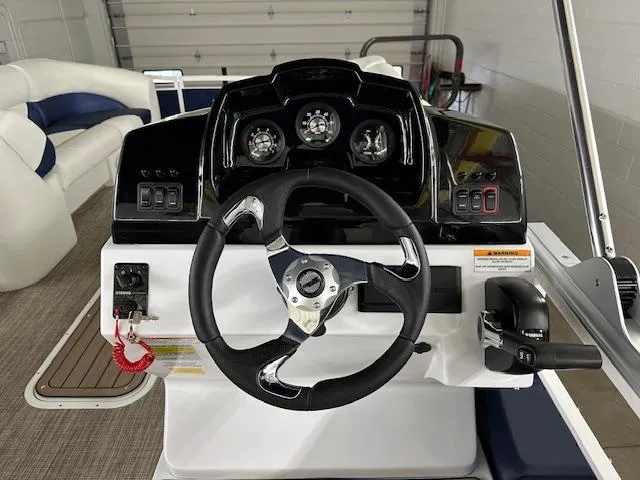 Slide: The Image of 2024 JC Spirit 221 TT Sport boat dashboard with steering wheel and control panel. - 15